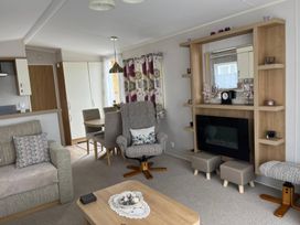 A living room with a dining table and chairs at Freshwater Beach Holiday Park - Holiday Accommodation 17116 Burton Bradstock near Bridport
