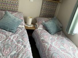 A bedroom with two beds and a bedside table at Freshwater Beach Holiday Park - Holiday Accommodation 17116, Burton Bradstock near Bridport