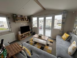 A living room with a sofa and television at Trecco Bay - Holiday Accommodation 17447 in Porthcawl