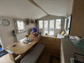 A living room with a table and sofa at Trecco Bay - Holiday Accommodation 17447 in Porthcawl