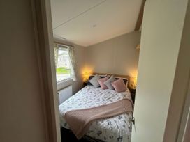 A bedroom with a bed and lamps at Trecco Bay - Holiday Accommodation 17447 Porthcawl