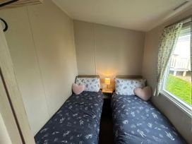 A bedroom with two single beds and a window at Trecco Bay - Holiday Accommodation 17447 in Porthcawl