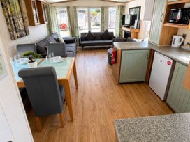 A living room with a sofa and dining area at Marsh Farm Holiday Park - Holiday Accommodation 17738, Great Yarmouth