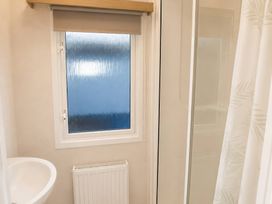 A bathroom with a sink, window, and shower at Marsh Farm Holiday Park - Holiday Accommodation 17738, Great Yarmouth