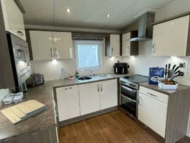 a kitchen with cabinets, a sink, stove, and appliances at Golden Palm Resort - Holiday Accommodation 17870, Chapel St Leonard's