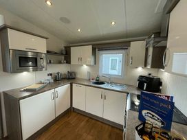 a modern kitchen with cabinets, appliances, and a window at Golden Palm Resort - Holiday Accommodation 17870, Chapel St Leonard's