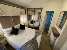 a bedroom with a bed, mirrored wardrobe, and a door at Golden Palm Resort - Holiday Accommodation 17870 Chapel St Leonard's