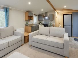 A living room with a sofa and kitchen area at Marton Mere Holiday Village - Holiday Accommodation 17890, Blackpool