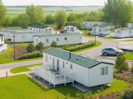 A mobile home with a deck in an outdoor area at Marton Mere Holiday Village - Holiday Accommodation 17890, Blackpool