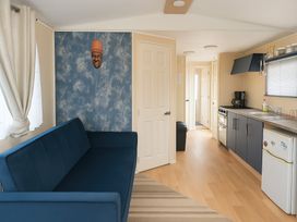 A living room with a sofa and kitchen area at Promenade Site - Holiday Accommodation 18142 in Skegness