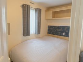 A bedroom with a bed and curtains at Promenade Site - Holiday Accommodation 18142 Skegness