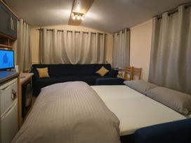 A living room with a bed and couch at Promenade Site - Holiday Accommodation 18142, Skegness