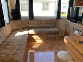 A living room with a sofa and television at Whitehouse Leisure Park - Holiday Accommodation 18340, Towyn