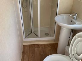 A bathroom with a shower, sink, and toilet at Whitehouse Leisure Park - Holiday Accommodation 18340, Towyn
