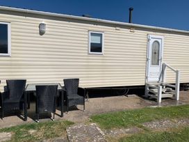 A mobile home with outdoor seating at Whitehouse Leisure Park - Holiday Accommodation 18340 Towyn