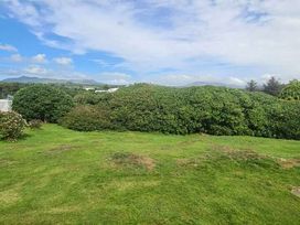 a green landscape with shrubs and blue sky at Hafan y Mor Haven - Holiday Accommodation 18358 in Pwllheli