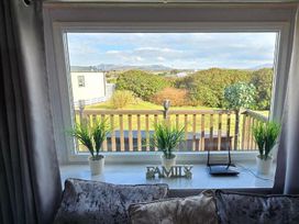 a window with view of greenery and mountains at Hafan y Mor Haven - Holiday Accommodation 18358 Pwllheli