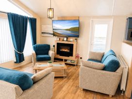 A living room with sofas and a television at Trecco Bay - Holiday Accommodation 18462, Porthcawl