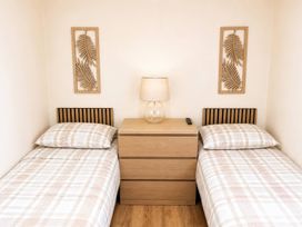 A bedroom with two beds and a nightstand at Trecco Bay - Holiday Accommodation 18462, Porthcawl