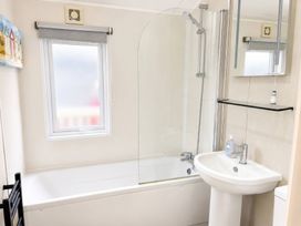 A bathroom with a bathtub and sink at Trecco Bay - Holiday Accommodation 18462, Porthcawl