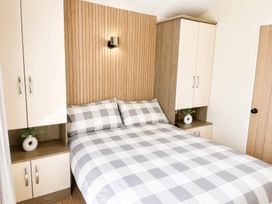 A bedroom with a bed and cabinets at Trecco Bay - Holiday Accommodation 18462, Porthcawl