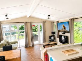 A living room with a sofa and television at Trecco Bay - Holiday Accommodation 18463 Porthcawl