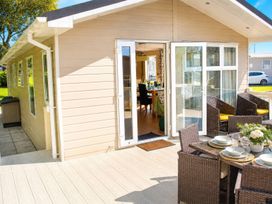 An outdoor dining area with chairs and a table at Trecco Bay - Holiday Accommodation 18463 Porthcawl