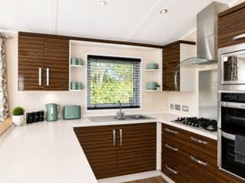 A kitchen with cabinets, sink, and appliances at Trecco Bay - Holiday Accommodation 18463 Porthcawl