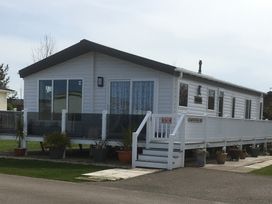A mobile home with a deck and steps at Manor Park Holiday Village - Holiday Accommodation 18468 Hunstanton