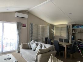 A living room with a sofa and dining table at Manor Park Holiday Village - Holiday Accommodation 18468 Hunstanton