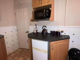 a kitchen with a microwave, kettle, and fridge at Promenade Site - Holiday Accommodation 18601 In Ingoldmells