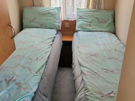 two single beds with light blue bedding and pillows in a small room at Promenade Site - Holiday Accommodation 18601 in Ingoldmells