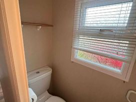 a bathroom with a toilet and a window at Promenade Site - Holiday Accommodation 18601 in Ingoldmells
