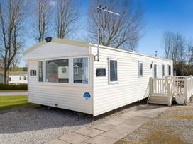 A mobile home with a deck and steps at Marton Mere Holiday Village - Holiday Accommodation 18682 Blackpool