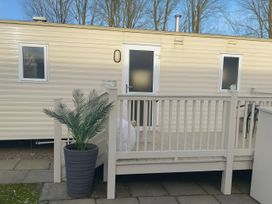 An outdoor view of a mobile home with a deck and a planter at Marton Mere Holiday Village - Holiday Accommodation 18682, Blackpool