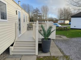 A deck area of a caravan with steps and a potted plant at Marton Mere Holiday Village - Holiday Accommodation 18682 Blackpool