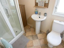 A bathroom with a shower, sink, and toilet at Marton Mere Holiday Village - Holiday Accommodation 18682, Blackpool