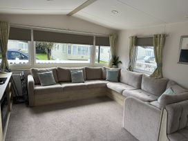 A living room with a couch and windows at Shorefield Country Park - Holiday Accommodation 18837 Lymington