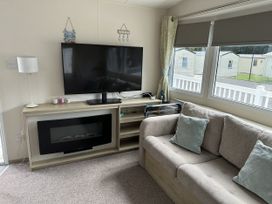 A living room with a television and couch at Shorefield Country Park - Holiday Accommodation 18837, Lymington