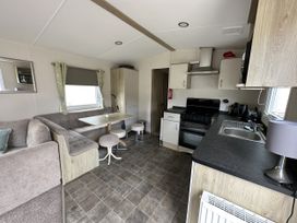 A kitchen with a sofa, table, and appliances at Shorefield Country Park - Holiday Accommodation 18837 Lymington