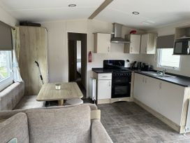 A kitchen with a dining table and appliances at Shorefield Country Park - Holiday Accommodation 18837 in Lymington