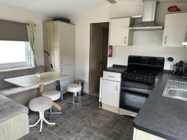 A kitchen with a table and stools at Shorefield Country Park - Holiday Accommodation 18837 Lymington