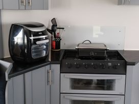 A kitchen with an air fryer and a gas stove at Millers Cottage Caravan Park - Holiday Accommodation 18845, Towyn, Abergele