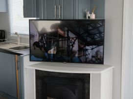 A kitchen with a television on a cabinet at Millers Cottage Caravan Park - Holiday Accommodation 18845, Towyn, Abergele