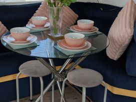 A dining table set with bowls and a vase at Millers Cottage Caravan Park - Holiday Accommodation 18845, Towyn, Abergele