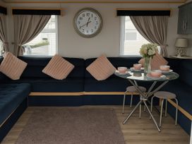 A living room with a sofa and table set at Millers Cottage Caravan Park - Holiday Accommodation 18845 Towyn, Abergele