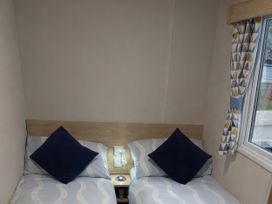 A bedroom with two beds and a lamp at Marton Mere Holiday Village - Holiday Accommodation 18865 Blackpool