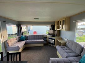 a living room with a seating area and television at Seaview Caravan Park - Holiday Accommodation 18903 in Ingoldmells