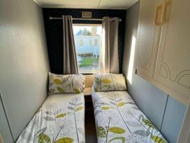 a bedroom with two single beds and a window at Seaview Caravan Park - Holiday Accommodation 18905 in Ingoldmells