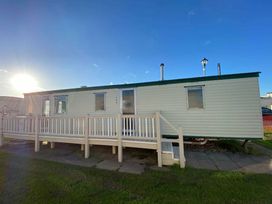 a holiday caravan with a deck and windows at Seaview Caravan Park - Holiday Accommodation 18905 in Ingoldmells